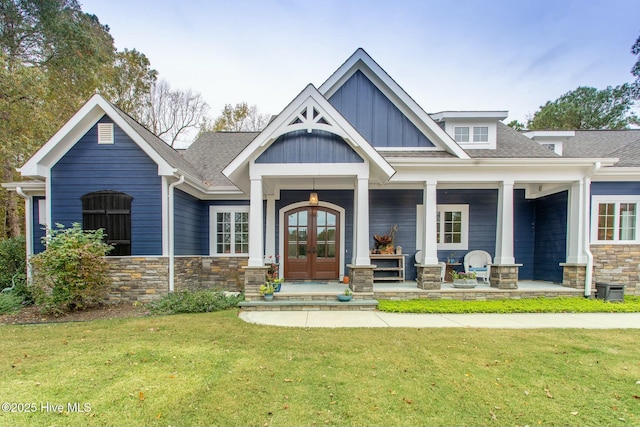 168 Highland Pony Dr, Hertford, NC 27944 - view of front of house with stone siding, a front yard, board and batten siding, and french doors