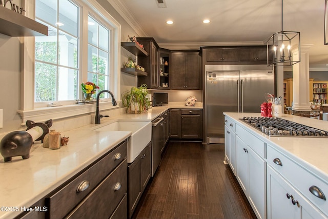 kitchen featuring stainless steel appliances, light countertops, crown molding, and dark brown cabinets