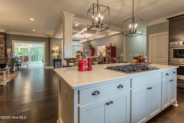 kitchen with dark wood finished floors, appliances with stainless steel finishes, open floor plan, ornamental molding, and light countertops