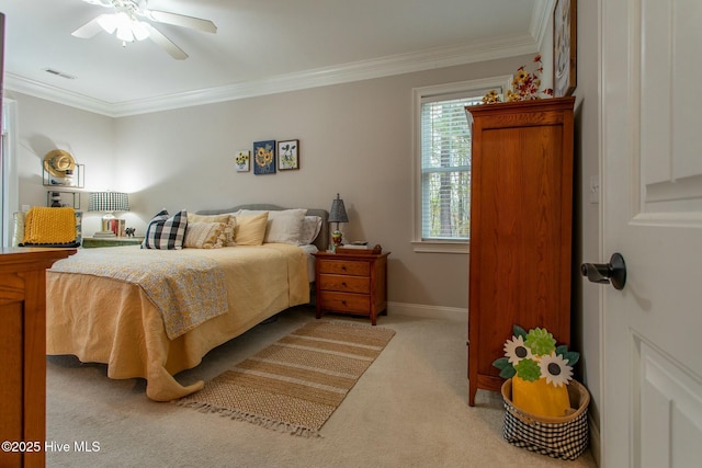 carpeted bedroom featuring a ceiling fan, visible vents, crown molding, and baseboards