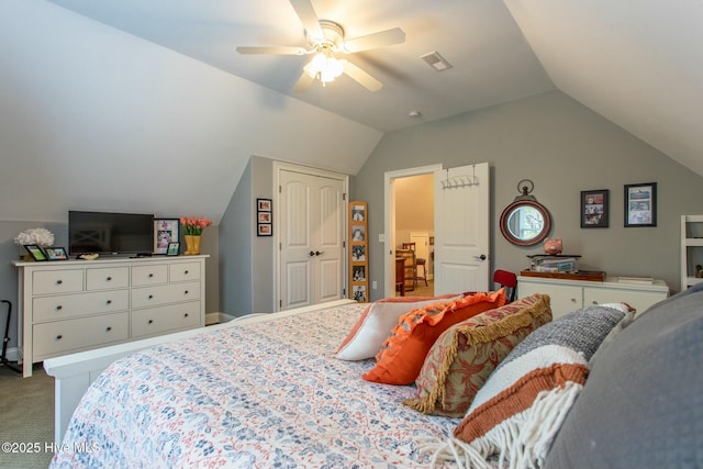 carpeted bedroom featuring lofted ceiling, visible vents, and a ceiling fan