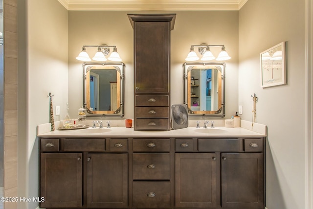 full bath with double vanity, crown molding, and a sink