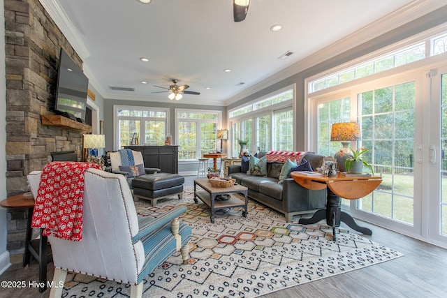 living room with recessed lighting, a fireplace, wood finished floors, visible vents, and crown molding