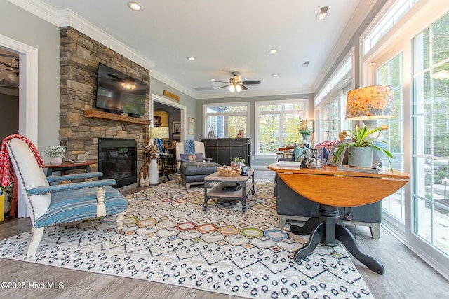 living room featuring recessed lighting, a fireplace, wood finished floors, visible vents, and ornamental molding