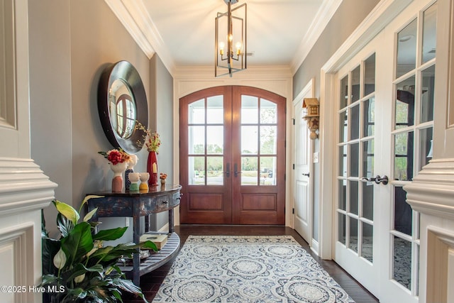 doorway to outside featuring ornamental molding, dark wood finished floors, arched walkways, and french doors