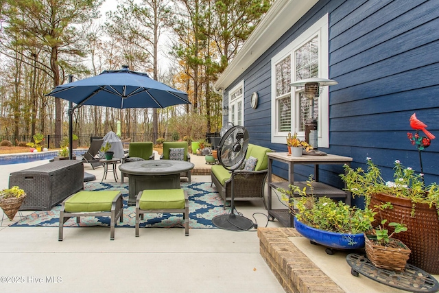 view of patio / terrace with a pool, an outdoor living space with a fire pit, and fence