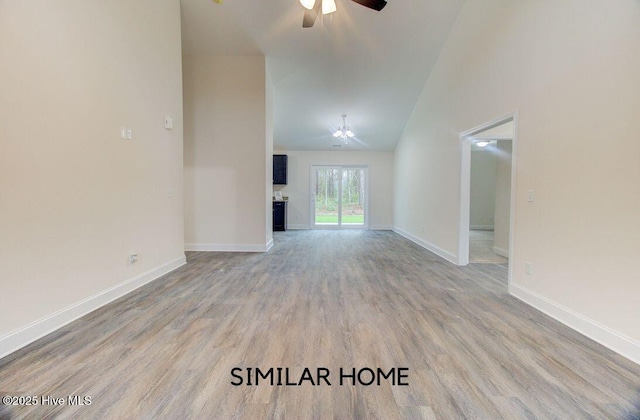 unfurnished living room featuring high vaulted ceiling, wood finished floors, a ceiling fan, and baseboards