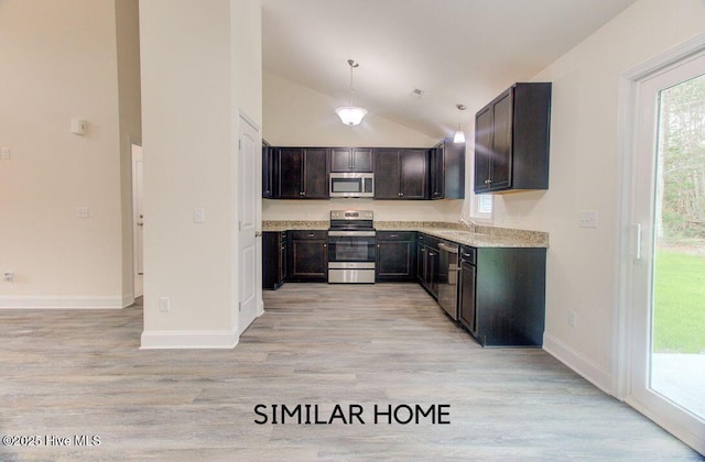 kitchen featuring light wood-style flooring, appliances with stainless steel finishes, light countertops, and a sink