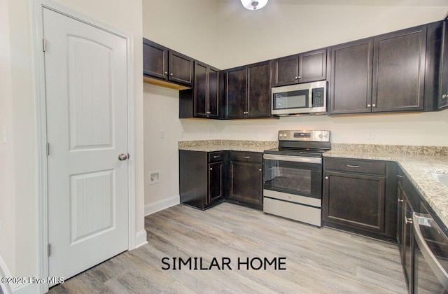 kitchen with dark brown cabinetry, light wood finished floors, baseboards, lofted ceiling, and stainless steel appliances