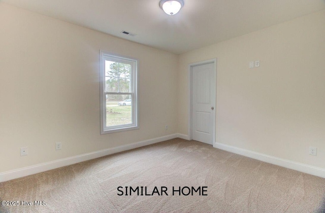 empty room with light carpet, visible vents, and baseboards