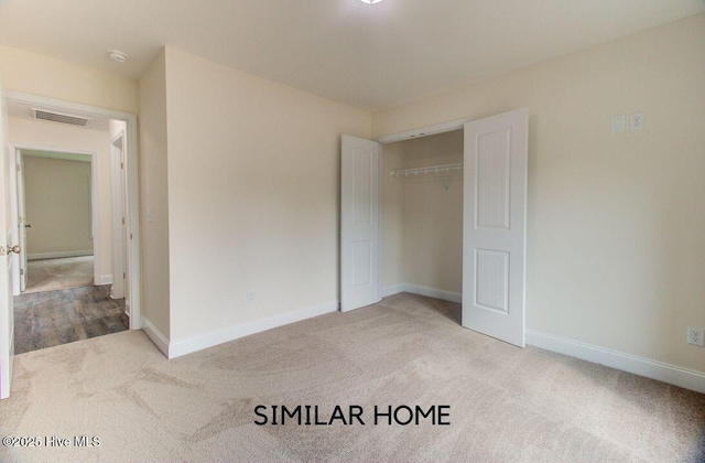 unfurnished bedroom featuring a closet, carpet, visible vents, and baseboards