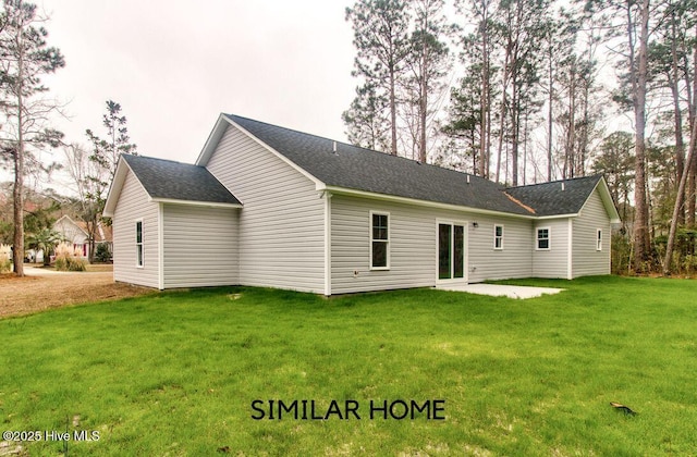 rear view of property with a patio area, roof with shingles, and a yard