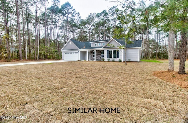 view of front of property featuring a garage, stone siding, a front yard, and driveway