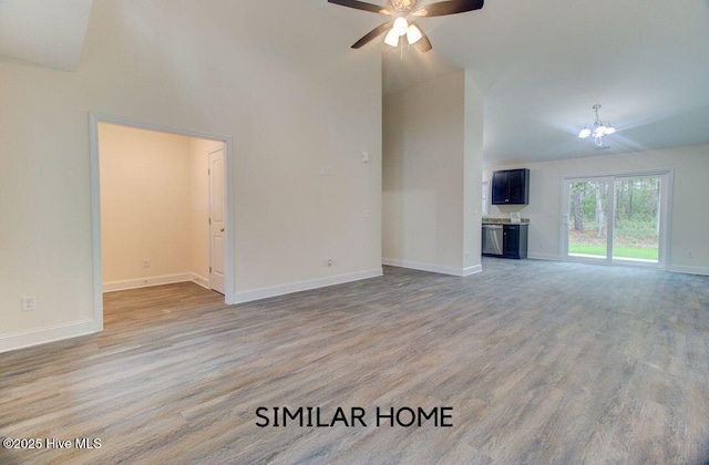 unfurnished living room with high vaulted ceiling, light wood-type flooring, baseboards, and ceiling fan with notable chandelier