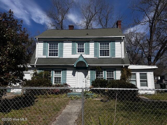 view of front of property with a fenced front yard and a chimney