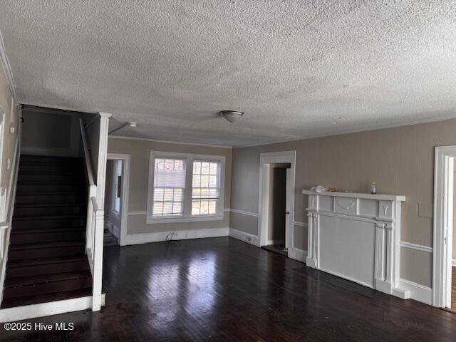 unfurnished living room featuring stairs, wood finished floors, and baseboards