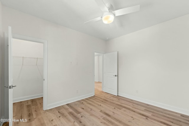 7103 E Yacht Dr, Oak Island, NC 28465 - unfurnished bedroom with a closet, baseboards, light wood-style flooring, and a spacious closet