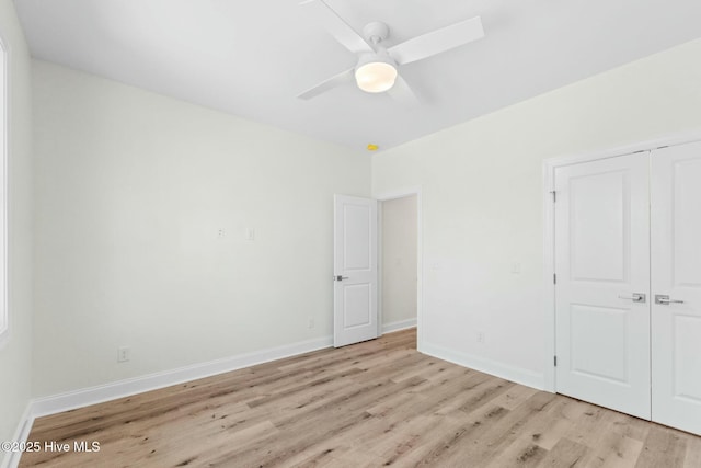 7103 E Yacht Dr, Oak Island, NC 28465 - unfurnished bedroom featuring a closet, baseboards, light wood-style floors, and ceiling fan