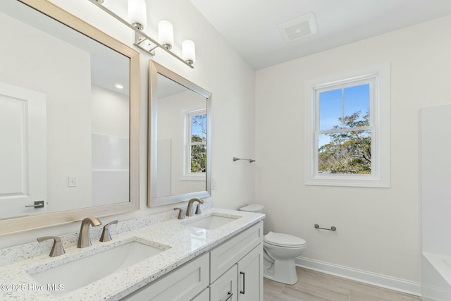 7103 E Yacht Dr, Oak Island, NC 28465 - full bath featuring a sink, baseboards, toilet, and double vanity