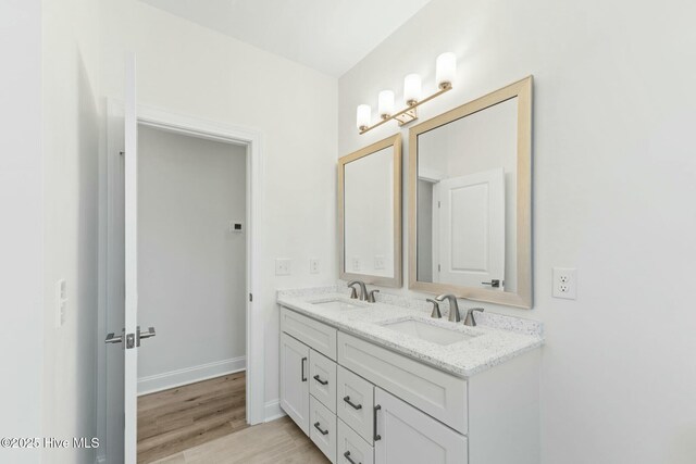 7103 E Yacht Dr, Oak Island, NC 28465 - bathroom with double vanity, wood finished floors, and baseboards