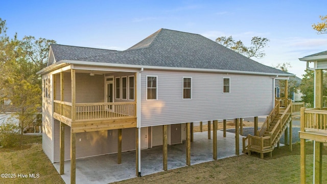 7103 E Yacht Dr, Oak Island, NC 28465 - back of house featuring stairway, a shingled roof, a carport, a patio area, and a lawn