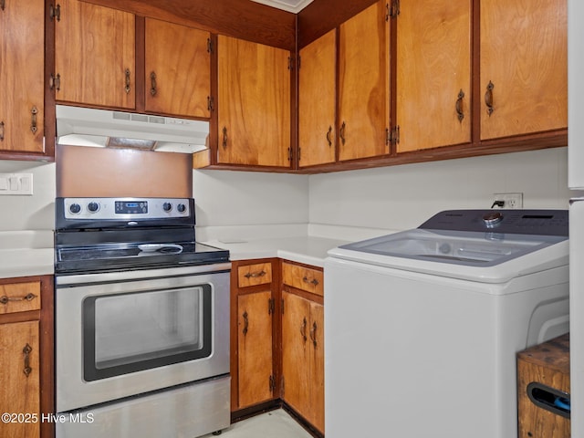 kitchen featuring under cabinet range hood, electric range, light countertops, washer / clothes dryer, and brown cabinetry