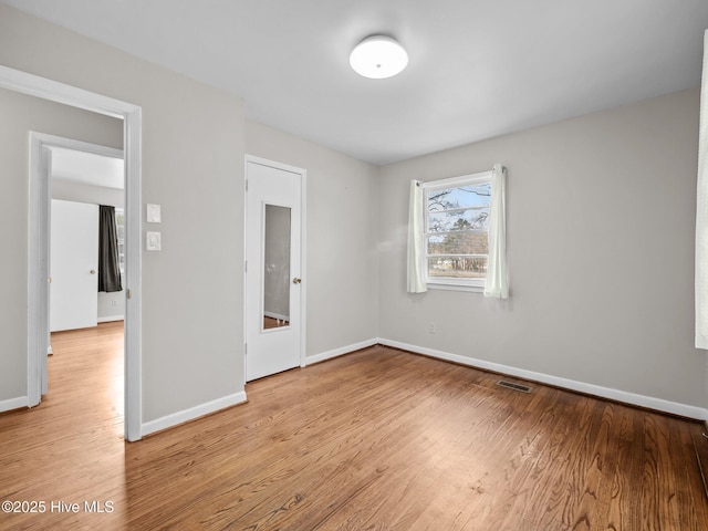 unfurnished bedroom featuring light wood-type flooring, baseboards, and visible vents