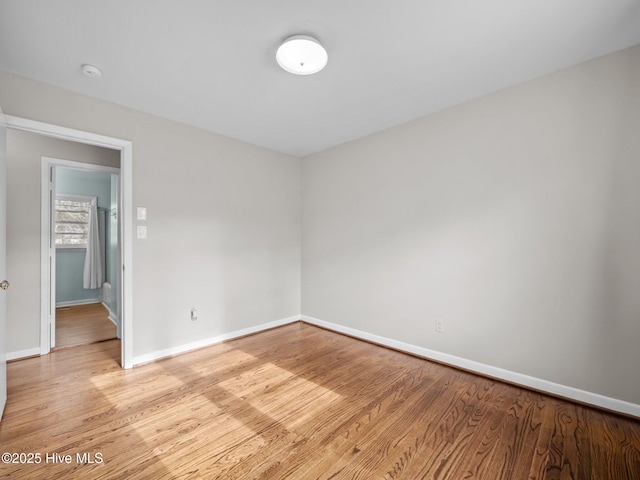 spare room with light wood-style flooring and baseboards