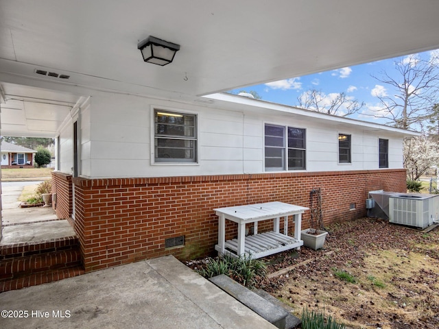 exterior space featuring brick siding, crawl space, and central AC unit