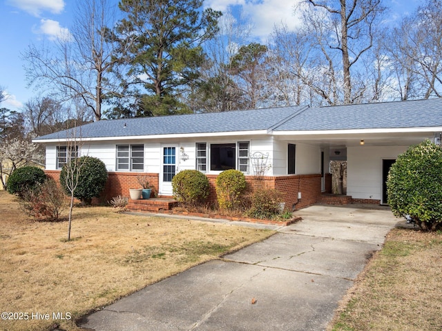 single story home with roof with shingles, a front lawn, concrete driveway, and brick siding