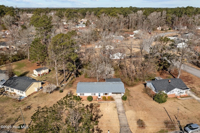 bird's eye view with a wooded view