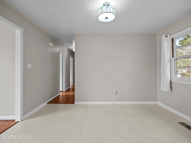 unfurnished room with baseboards and visible vents