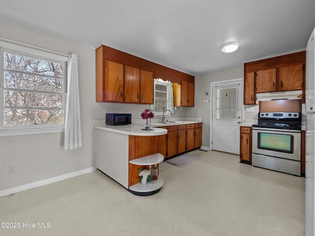 kitchen featuring light floors, a sink, under cabinet range hood, and stainless steel electric range