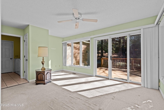 interior space featuring carpet flooring, a ceiling fan, baseboards, and a textured ceiling