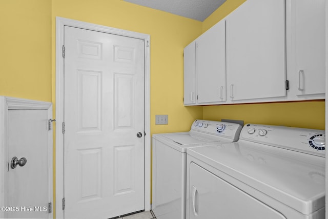 clothes washing area with cabinet space, light tile patterned floors, independent washer and dryer, and a textured ceiling