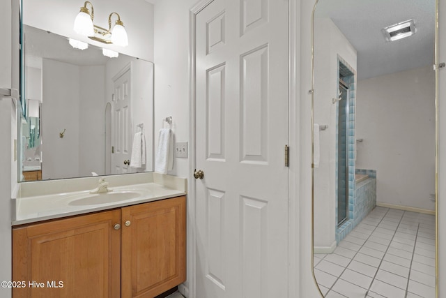 bathroom with tile patterned flooring, a stall shower, vanity, and baseboards