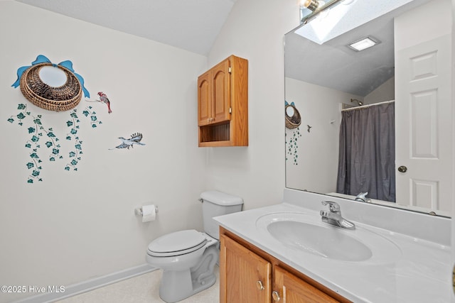 bathroom with vanity, vaulted ceiling with skylight, a textured ceiling, curtained shower, and toilet