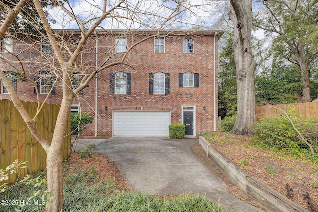 view of front of home with a garage, brick siding, fence, and driveway