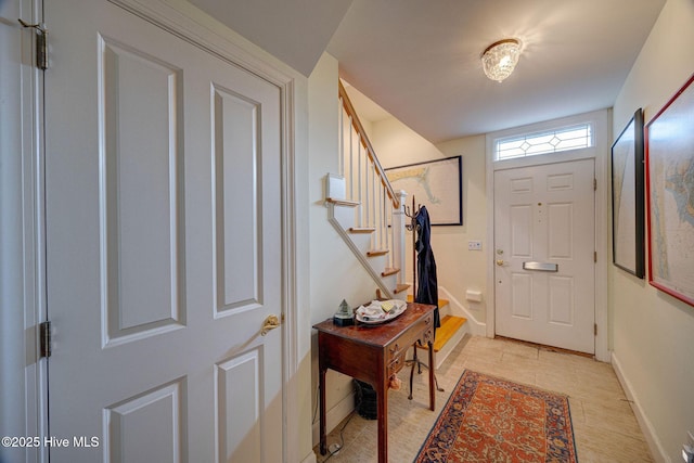 foyer with baseboards and stairs