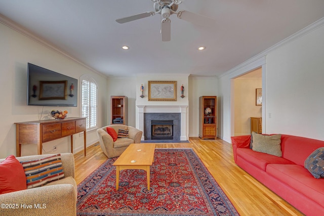 living room with a fireplace with flush hearth, baseboards, wood finished floors, and crown molding