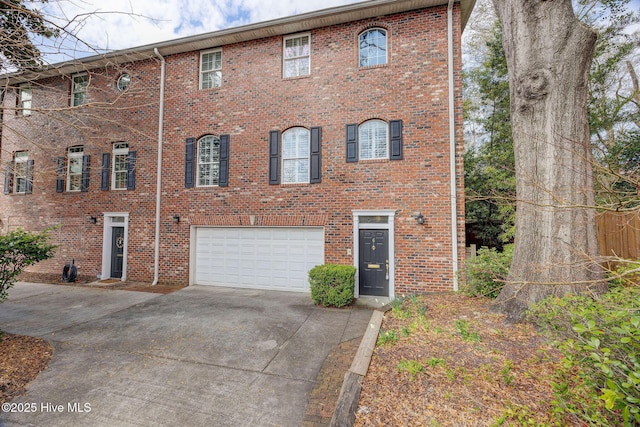 view of front of property featuring a garage, concrete driveway, and brick siding