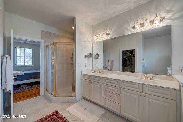 ensuite bathroom featuring double vanity, tile patterned flooring, a sink, and a shower stall