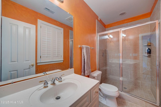 bathroom featuring toilet, a shower stall, visible vents, and vanity