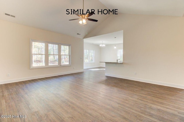 unfurnished living room featuring baseboards, visible vents, dark wood-type flooring, and ceiling fan with notable chandelier