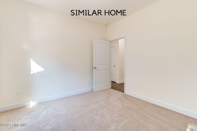 spare room with carpet and baseboards