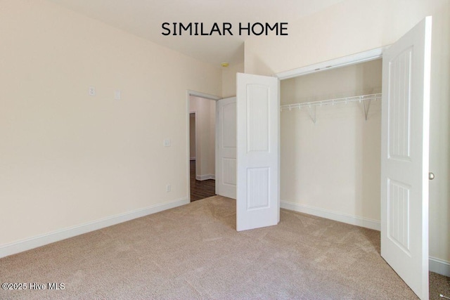 unfurnished bedroom with a closet, carpet, and baseboards