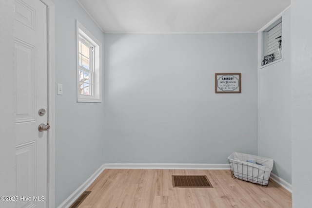 interior space with visible vents, baseboards, and wood finished floors