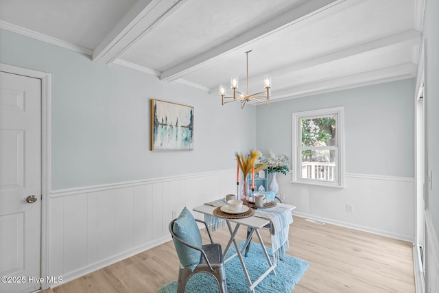 dining space with wood finished floors, visible vents, beam ceiling, wainscoting, and a chandelier