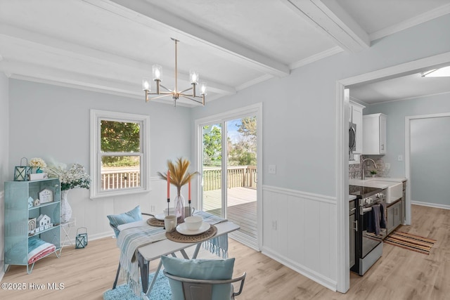 dining room with beam ceiling, a chandelier, and light wood finished floors