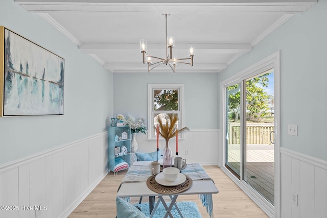 living area featuring light wood-type flooring, beamed ceiling, and wainscoting